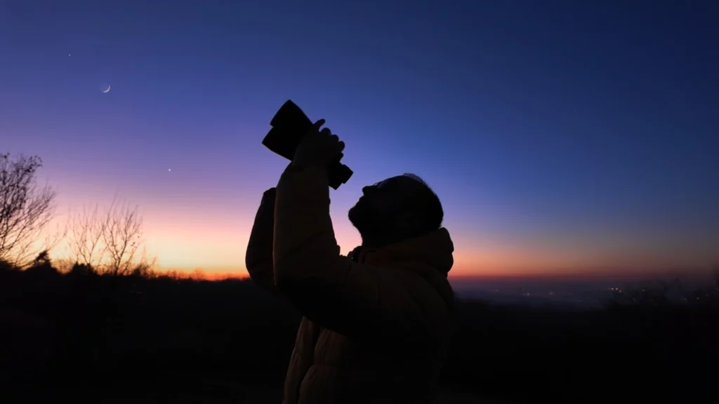 photo d'une personne en train d'observer le ciel nocturne avec des jumelles